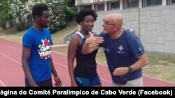 Keula Nidreia Semedo, corredora paralímpica de Cabo Verde (cen), com o guia Manuel António da Veiga, (esq) e um técnico