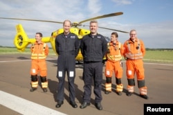 Britain's Prince William poses with crew members of the East Anglian Air Ambulance at Cambridge Airport, England, July 27, 2017.