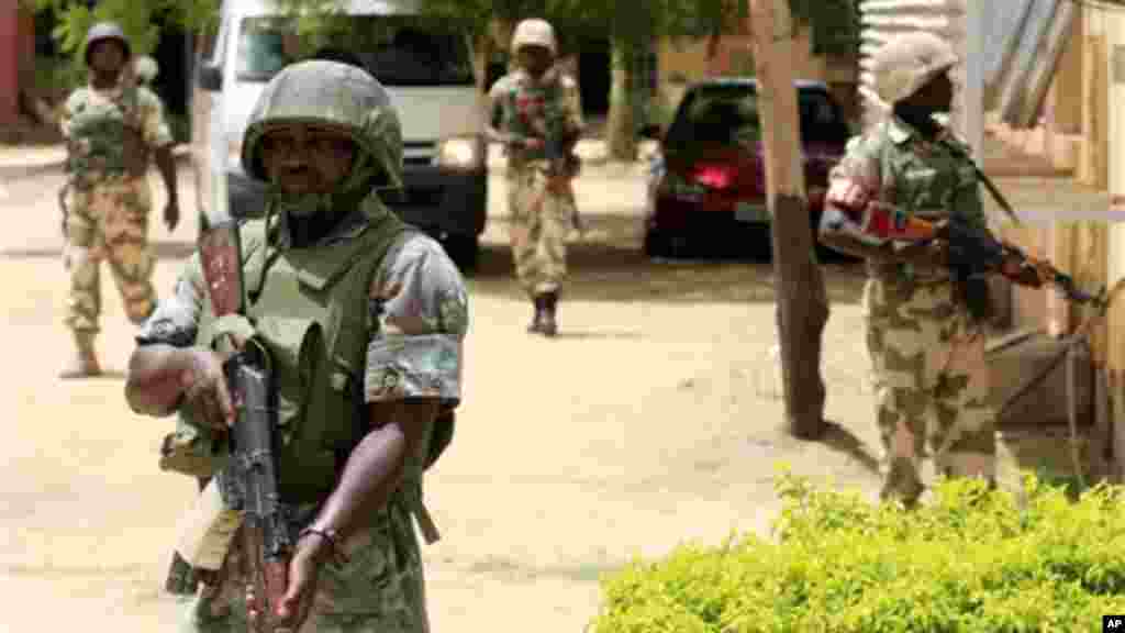 Soldiers stand guard at the offices of the state-run Nigerian Television Authority in Maiduguri, Nigeria.