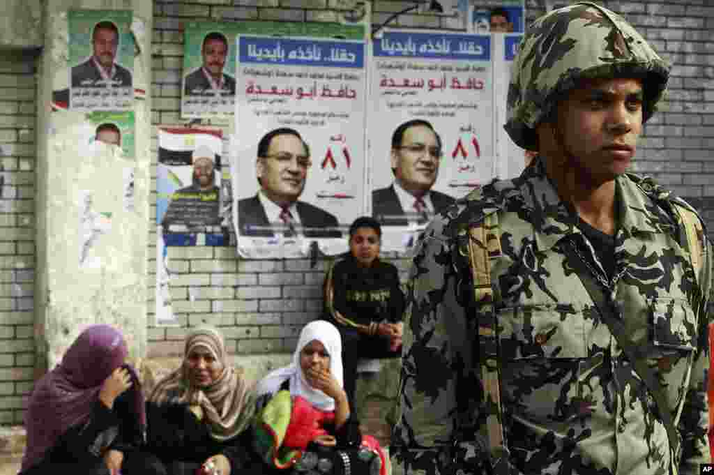 An army soldier stands guard outside a polling station during parliamentary elections in the Moqattam district of Cairo, November 29, 2011. (Reuters)