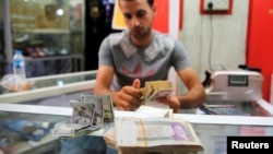 FILE - Iranian rials are seen at a currency exchange shop in Baghdad, Iraq, Aug. 8, 2018.
