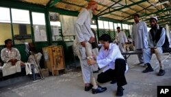 FILE - A medic adjusts a prosthetic leg at the International Committee of the Red Cross orthopedic hospital in Kabul, Afghanistan, Saturday, July 17, 2010.