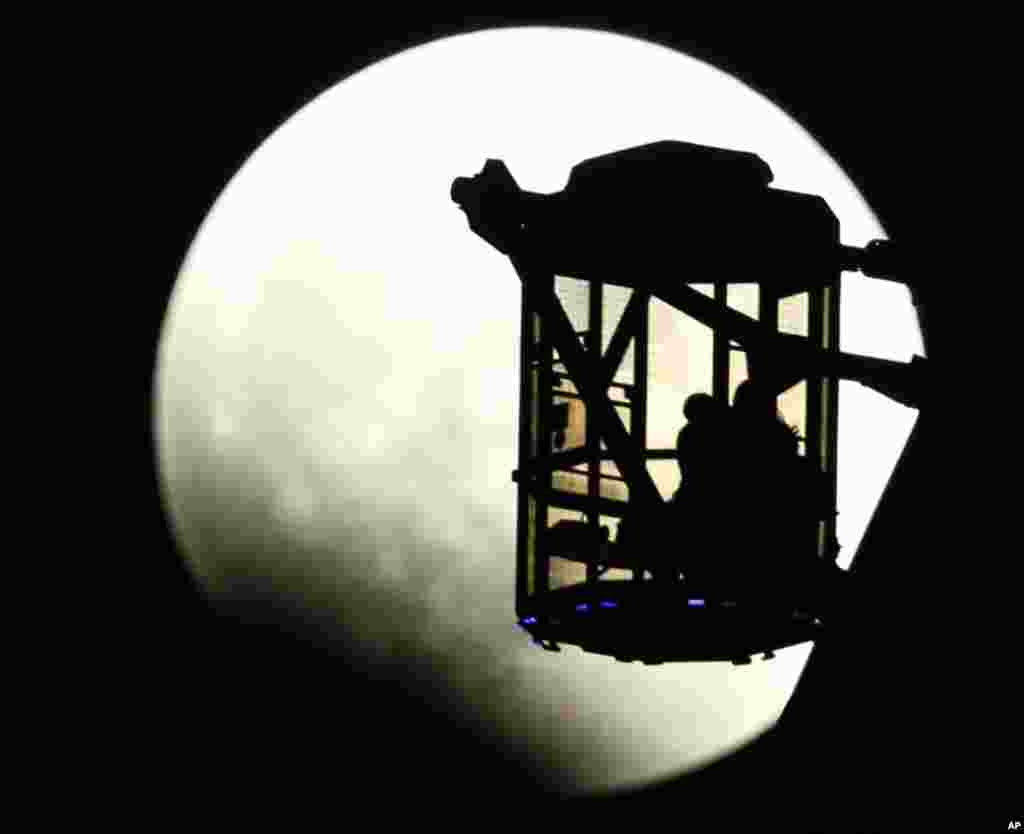  A couple on a Ferris wheel observes the Earth's shadow crossing the moon during a total lunar eclipse in Tokyo, Japan, Oct. 8, 2014.