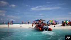 FILE - Chinese tourists enjoy scenic Quanfu island, a Paracels of Sansha prefecture of China's Hainan province, Sept. 14, 2014.