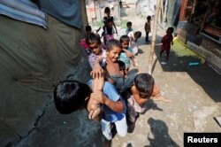 Children from the Rohingya community play outside their shacks in a camp in New Delhi, Oct. 4, 2018.