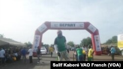 Un des acrobates du Tour du Faso en pleine animation sur la ligne d'arrivée à Bobo-Dioulasso, le 5 novembre, 2015. (Salif Kaboré, VOA)
