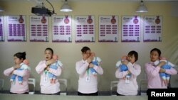 资料照：北京的一所阿姨训练学校在培训保姆如何照顾新生儿。（2018年12月5日）