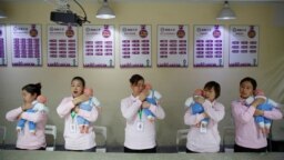 资料照：北京的一所阿姨训练学校在培训保姆如何照顾新生儿。（2018年12月5日）