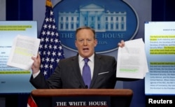 White House spokesman Sean Spicer holds up documents comparing the makeup of the National Security Council (NSC) in the Trump and Obama administrations during his press briefing at the White House in Washington, D.C., Jan. 30, 2017.