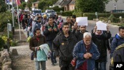 FILE - Middle Eastern migrants, who came from Germany by ferry and train, walk from Rodby in southern Denmark toward Sweden, Sept. 7, 2015. 