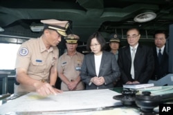 In this image taken and made available by the Taiwan Presidential Office, Taiwan's President Tsai Ing-wen (center right) reviews nautical charts aboard a Taiwan Navy ship before it sets out to patrol in the South China Sea.