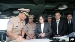 FILE - In this image taken and made available by the Taiwan Presidential Office, Taiwan's President Tsai Ing-wen, center right, reviews nautical charts aboard a Taiwan navy ship before it sets out to patrol in the South China Sea from Khaohsiung, Taiwan, July 13, 2016.