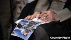 A photo shows Iran’s supreme leader, Ayatollah Ali Khamenei, signing a poster of a fallen shrine defender. Source: Khamenei.ir
