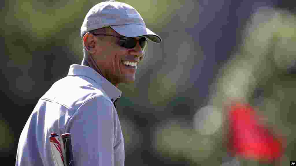 Le président Barack Obama joue au golf, couvert d&#39;une casquette, 12 août 2015.