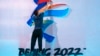 FILE - A crew member fixes a logo for the 2022 Beijing Winter Olympics before a launch ceremony to reveal the motto for the Winter Olympics and Paralympics in Beijing on Sept. 17, 2021. 