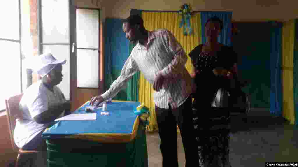 Un électeur retire le bulletin de vote avant de choisir son candidat, à Kigali, Rwanda, 4 août 2017. (VOA/Charly Kasereka)