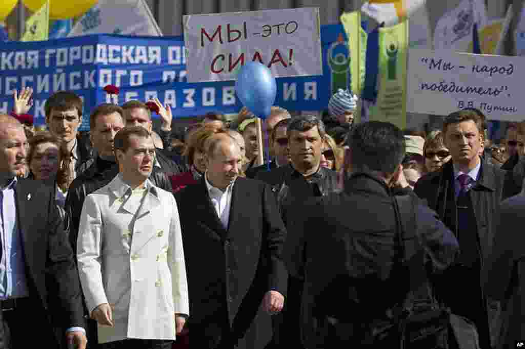 Russian President Dmitry Medvedev, 2nd left, and president-elect Vladimir Putin, 3rd left, take part in a May Day rally, organized by trade unions and United Russia party, in Moscow, Russia, May 1, 2012. (AP Photo)