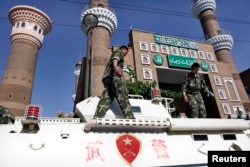 中國警察2008年10月8日在烏魯木齊一所清真寺前搭乘裝甲車執勤