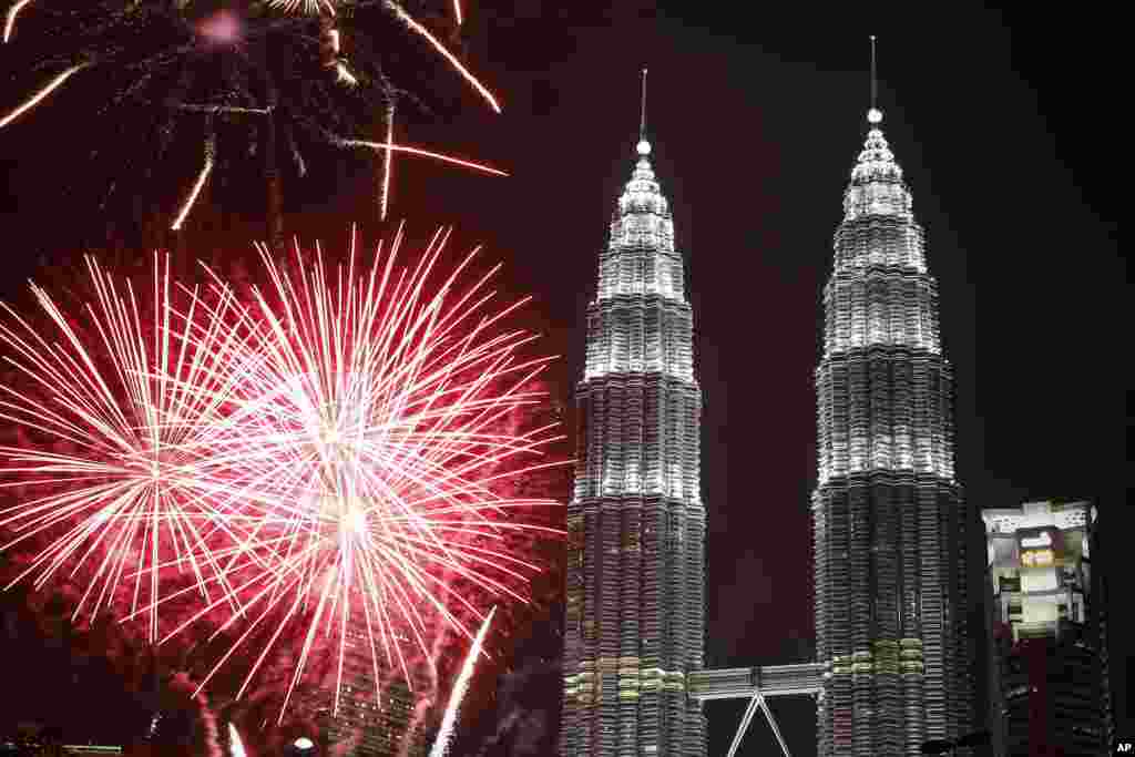 Fireworks explode in front of Malaysia&#39;s landmark building, Petronas Twin Towers, during the New Year&#39;s Eve celebration in Kuala Lumpur.