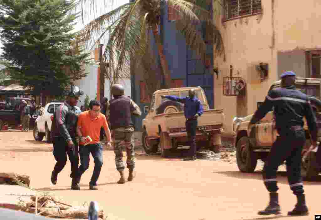 Pessoas fogem do hotel Radisson Blu em Bamako, capital do Mali, durante o ataque de um grupo extremista que tomou de assalto o hotel e fez 170 pessoas reféns
