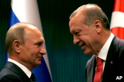 FILE - In this Sept. 28, 2017 file photo, Turkish President Recep Tayyip Erdogan, right, shakes hands with Russian President Vladimir Putin in Ankara, Turkey.