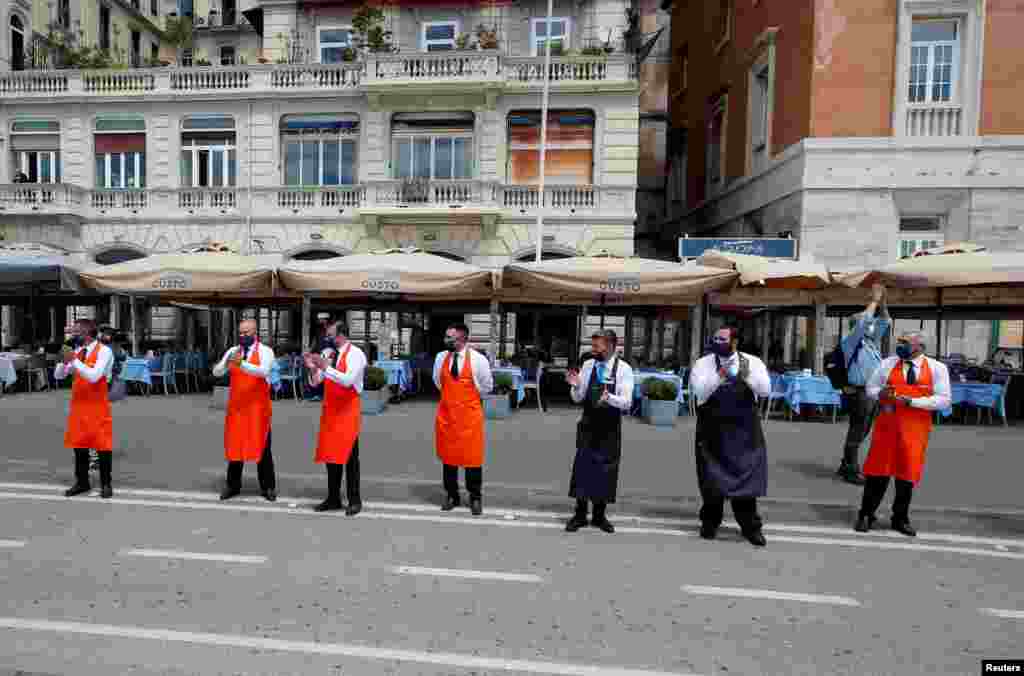 Workers applaud to thank health workers for their battle against the coronavirus disease (COVID-19) before their restaurants&#39; reopening on the waterfront in Naples, as Italy eases some of the lockdown measures put in place during the COVID-19 pandemic.