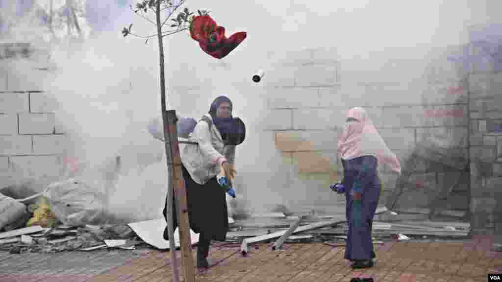 Female Islamist students throw projectiles at police during a protest at Al-Azhar University in Cairo, Dec. 11, 2013. (Hamada Elrasam for VOA)