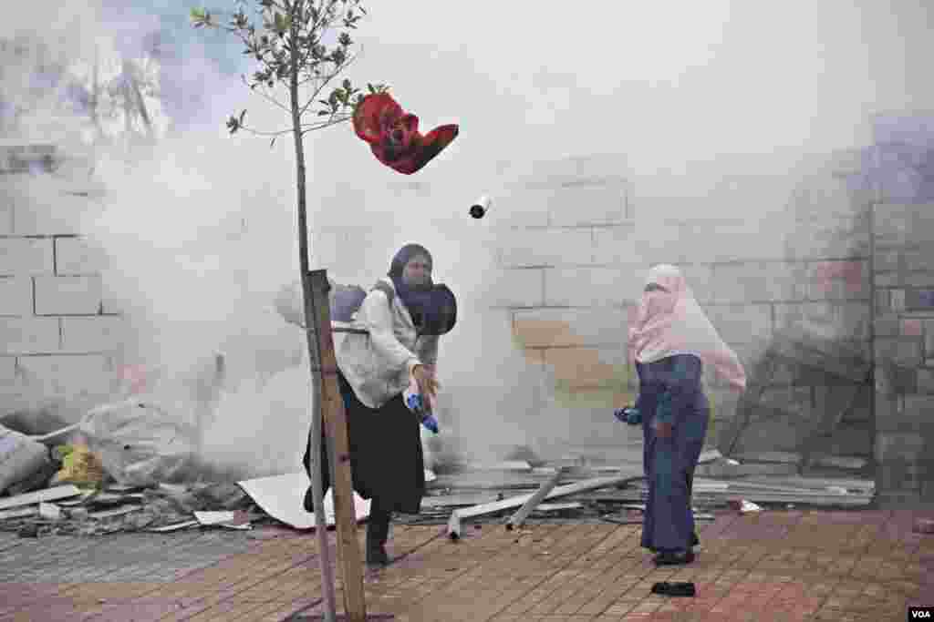 Female Islamist students throw projectiles at police during a protest at Al-Azhar University in Cairo, Dec. 11, 2013. (Hamada Elrasam for VOA)