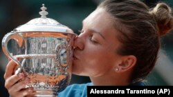 Rumunska teniserka Simona Halep ljubi trofej posle osvajanja svog prvog Rolan Garosa (Foto: AP/Alessandra Tarantino)