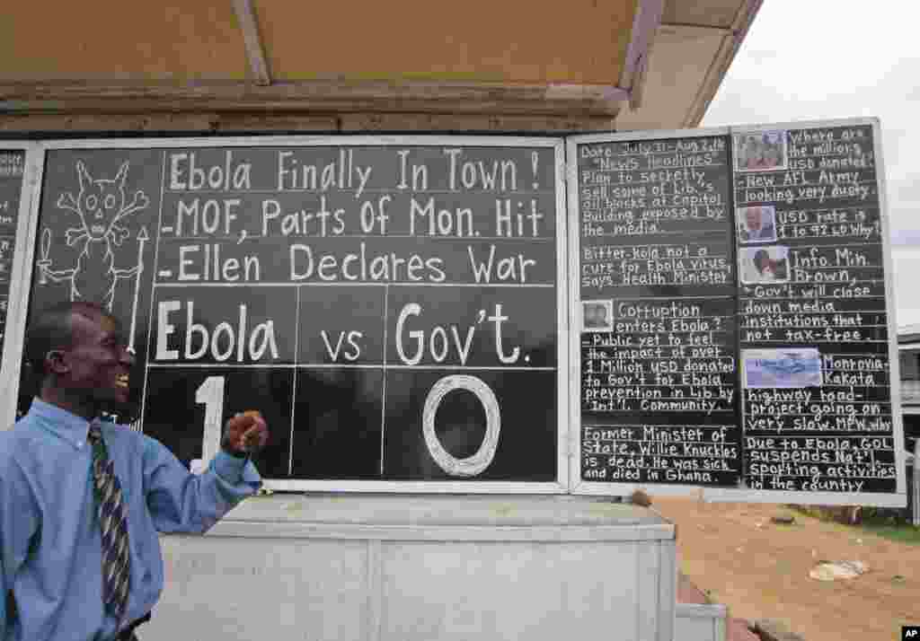 Social commentator Alfred Sirleaf gives comment on current events in Liberia including the deadly Ebola virus by writing them on a blackboard, in Monrovia, Liberia, July 31, 2014.