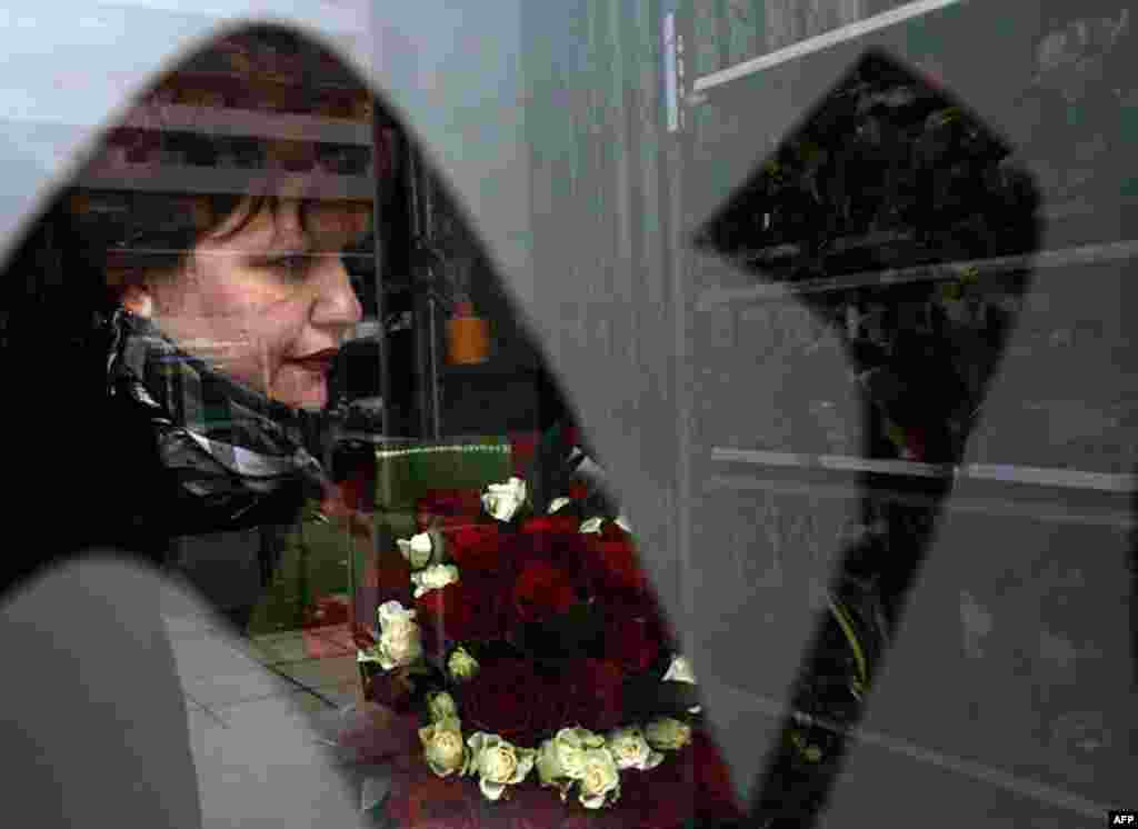 A woman holds roses on Valentine's Day at a flower shop in Tirana, February 14, 2012. (REUTERS)