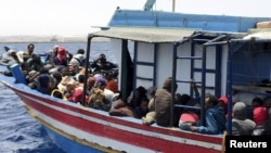 Illegal migrants who attempted to sail to Europe, sit in a boat carrying them back to Libya, after their boat was intercepted at sea by the Libyan coast guard, at Khoms, Libya, May 6, 2015. 