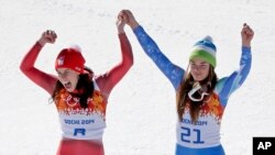 Women's downhill gold medal winners Switzerland's Dominique Gisin, left, and Slovenia's Tina Maze step onto the podium together at the Sochi 2014 Winter Olympics, Feb. 12, 2014, in Krasnaya Polyana, Russia.