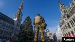 A Belgian soldier patrols in Brussels' Grand Place as police searched the area during a continued high level of security following the recent deadly Paris attacks, Belgium, Nov. 23, 2015. 