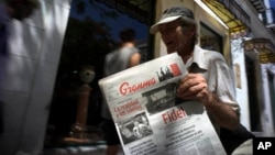 FILE - A vendor holds a copy of Cuba's state newspaper Granma, in Havana, Cuba, Aug. 13, 2015. 