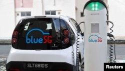 A BlueSG electric car-sharing vehicle is parked at a charging station in a public housing estate in Singapore