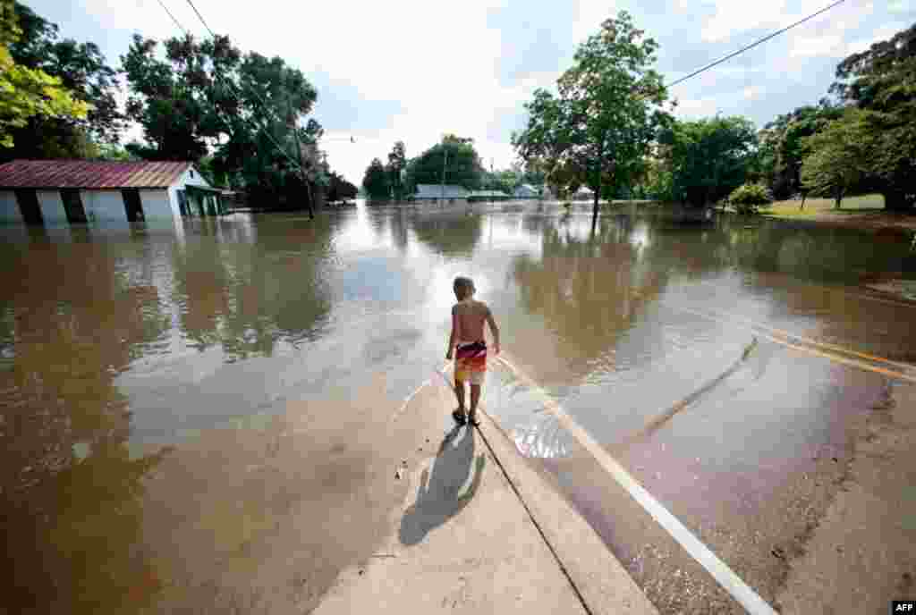 May 19: Landon Bonaventure, 5, walks to the edge of floodwater from the Mississippi River in St. Francisville, La. (AP Photo)