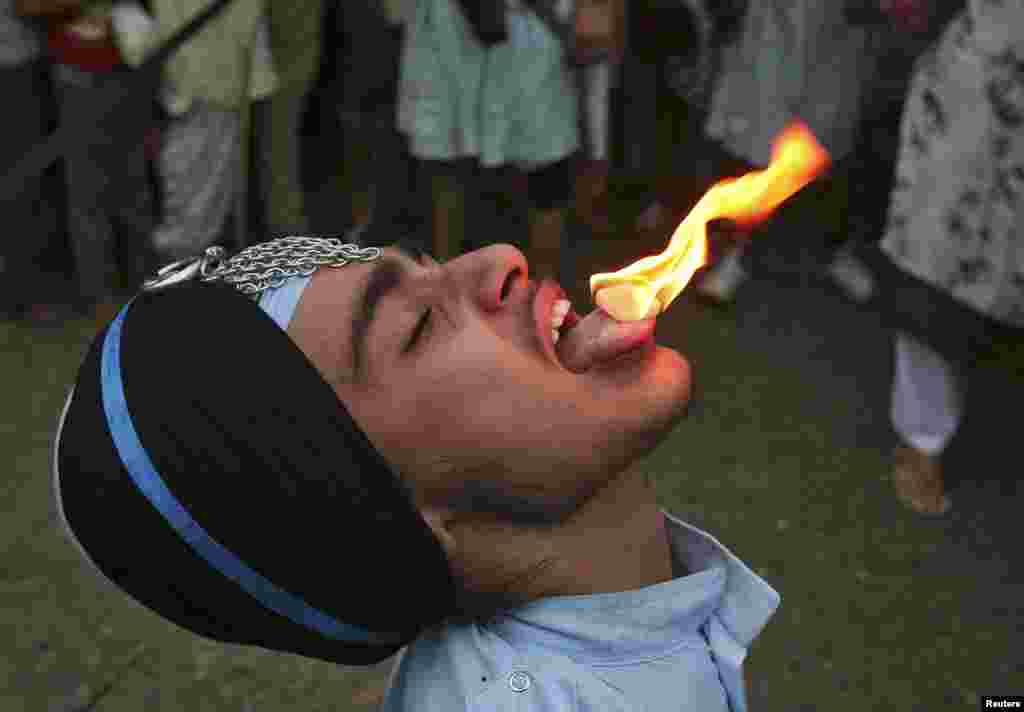 A Sikh man performs a stunt with fire during the celebrations of the 410th anniversary of the installation of the Guru Granth Sahib, the religious book of Sikhs, in the northern Indian city of Amritsar.