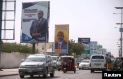 Motorists drive along a street with the campaign billboards of Somalia's Presidential candidates in Somalia's capital Mogadishu, Feb. 6, 2017.