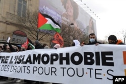 Para pengunjuk rasa membentangkan spanduk dan bendera Palestina dalam unjuk rasa menentang RUU "antiseparatisme" dan Islamofobia di Paris, Perancis, 21 Maret 2021. (Foto: Alain Jocard/AFP)