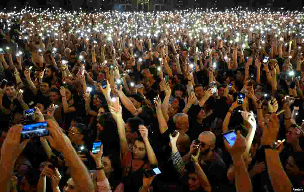 People light up their mobile phones as they attend a protest rally in front of the parliament building in Tbilisi, Georgia.