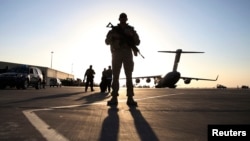 Un soldado monta guardia frente a un avión C-17 Globemaster III. Un 47% del público estadounidense no quiere que se reduzca el gasto militar.