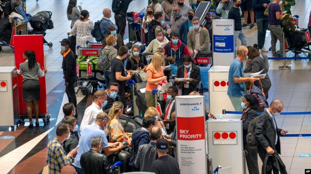 Dozens of people line up to catch an Air France flight to Paris at Tambo International Airport in Johannesburg, South Africa, Nov. 26, 2021.