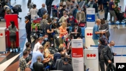 Dozens of people line up to catch an Air France flight to Paris at Tambo International Airport in Johannesburg, South Africa, Nov. 26, 2021.