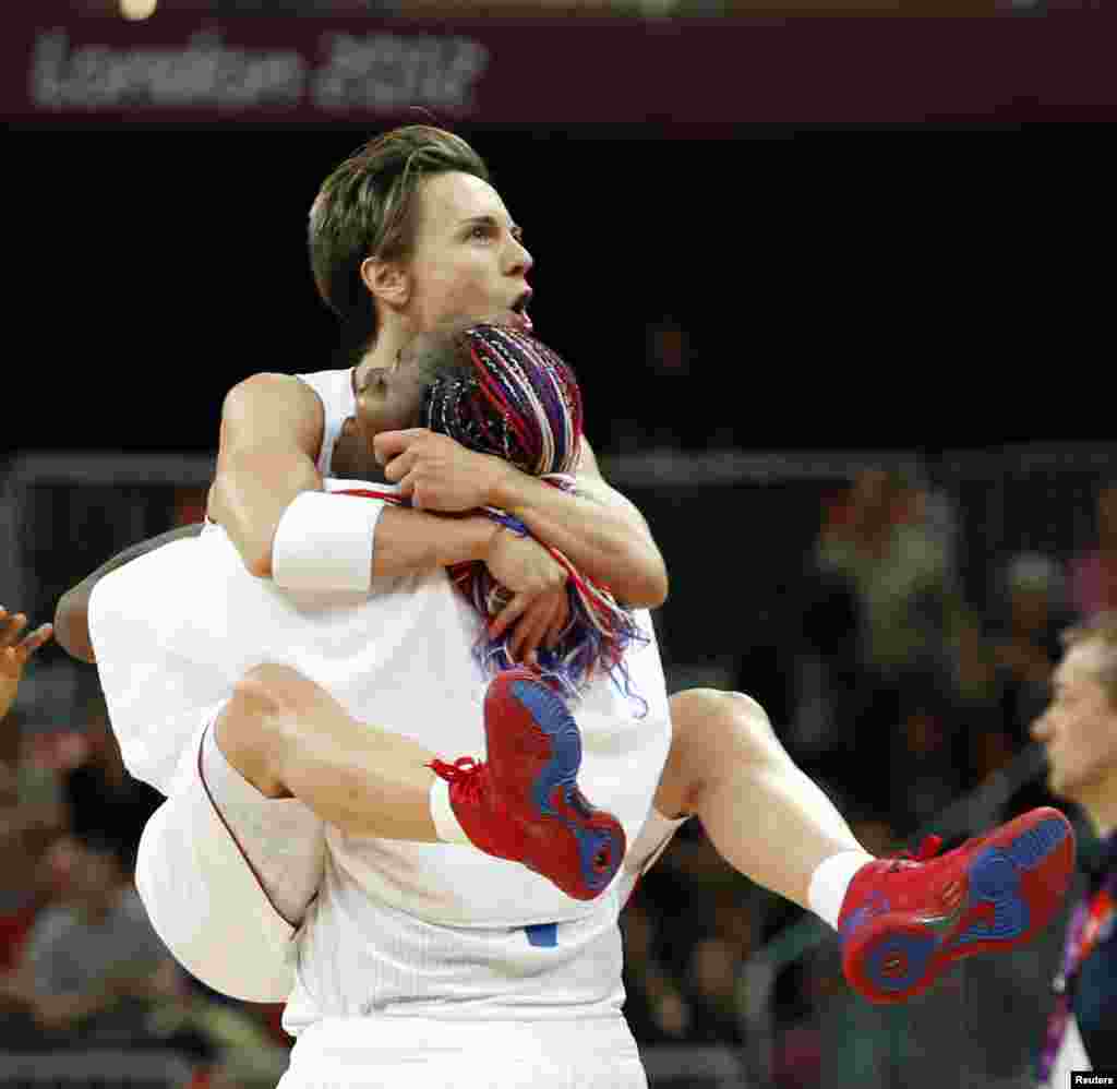 Celine Dumerk, de Francia, salta a los brazos de su compañera Isabelle Yacoubou mientras celebran su victoria contra Australia luego de jugar un partido de baloncesto en las preliminares feneminas del grupo B.