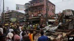 Rescue workers search for survivors amid the rubble of a collapsed building in a densely populated neighborhood in Lagos, Nigeria, July 25, 2017. 