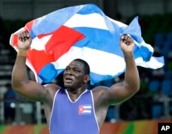 Cuba's Mijain Lopez Nunez celebrates after beating Turkey's Riza Kayaalp to win the gold in the men's wrestling Greco-Roman 130-kg competition at the 2016 Summer Olympics in Rio de Janeiro, Brazil, Aug. 15, 2016.