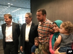 Egyptian Al-Jazeera English journalist Baher Mohammed and his family are welcomed by his colleagues in Doha, Qatar, Oct. 14, 2015.