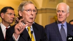 FILE - Senate Majority Leader Mitch McConnell of Ky., accompanied by Sen. John Barrasso, R-Wyo., left, and Senate Majority Whip John Cornyn of Texas., meet with reporters on Capitol Hill.