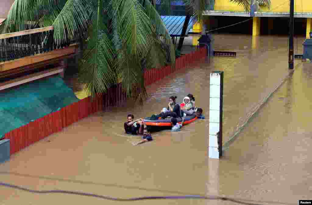 Rescue workers evacuate people from flooded areas after the opening of Idamalayr, Cheruthoni and Mullaperiyar dam shutters following heavy rains, on the outskirts of Kochi, India.